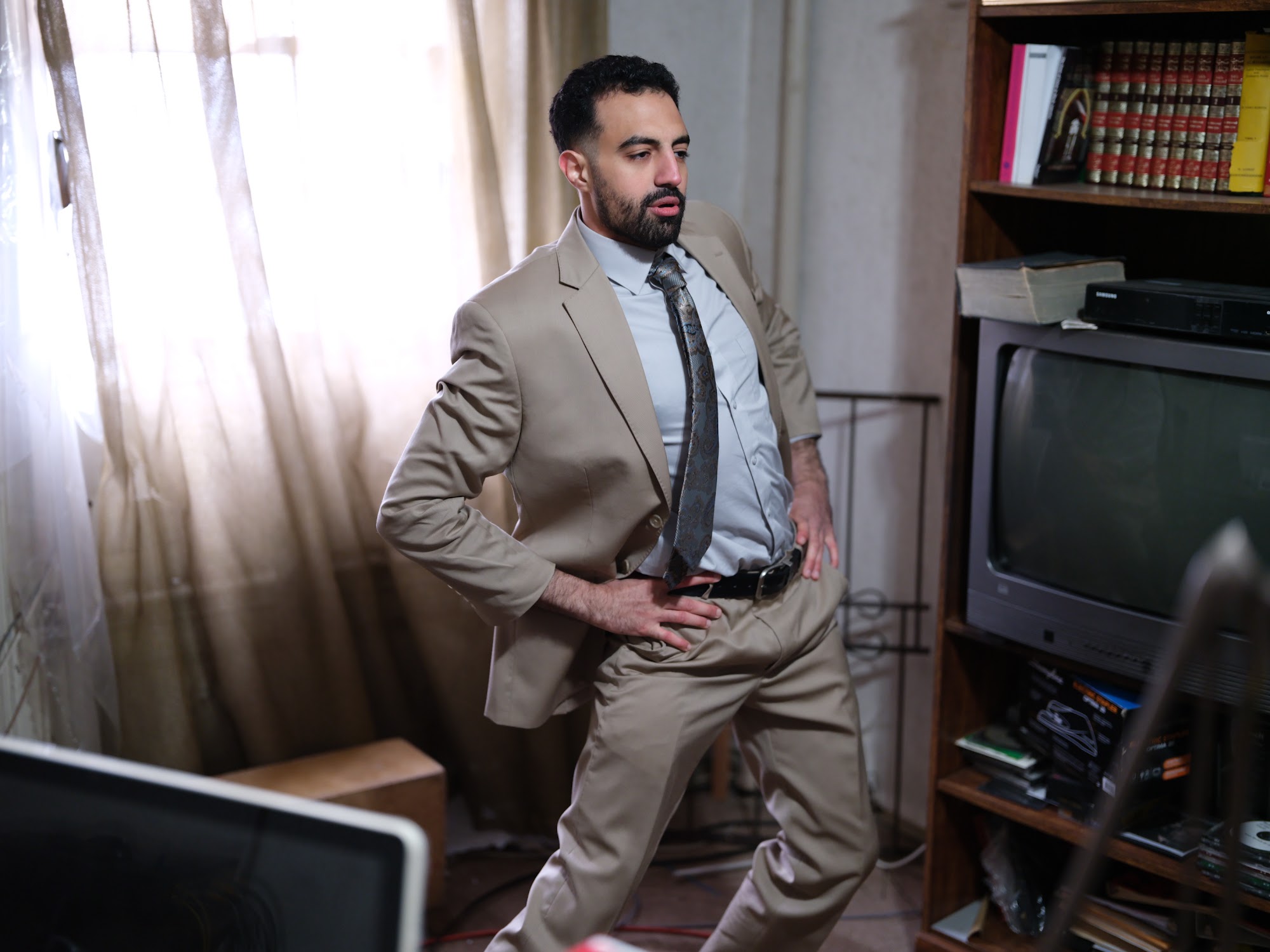 Omar in a tan suit inside the world of the show