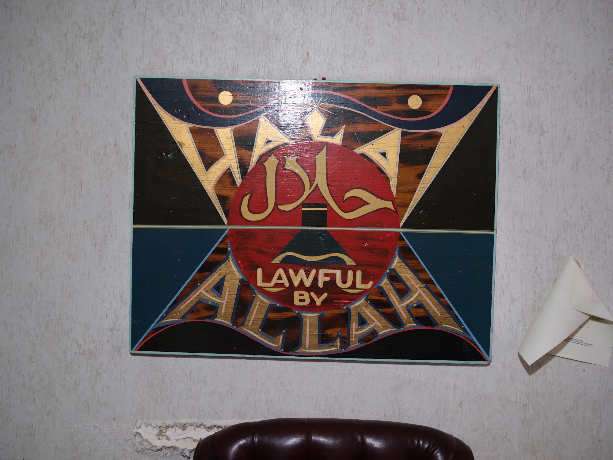 Hand-painted halal sign reading Lawful by Allah, from the world of the series